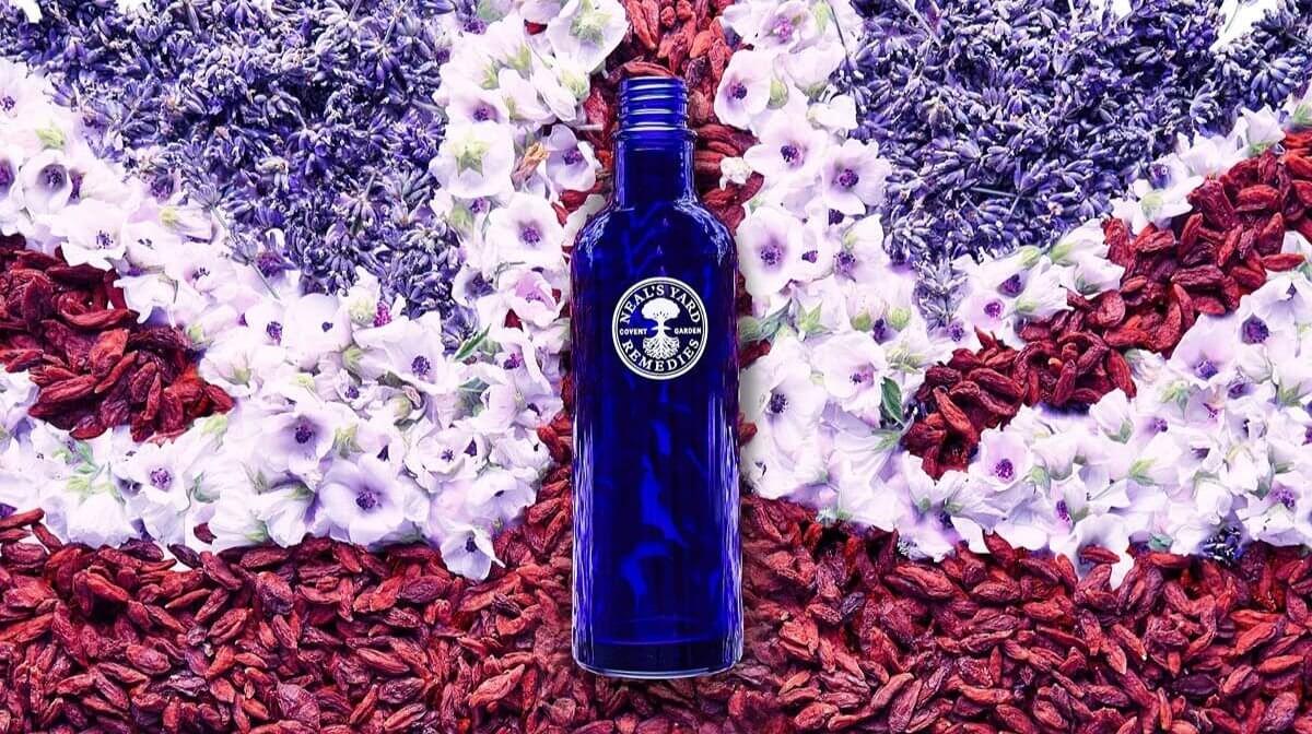 Neal's Yard Remedies blue bottle on a Union Jack flag made of flowers